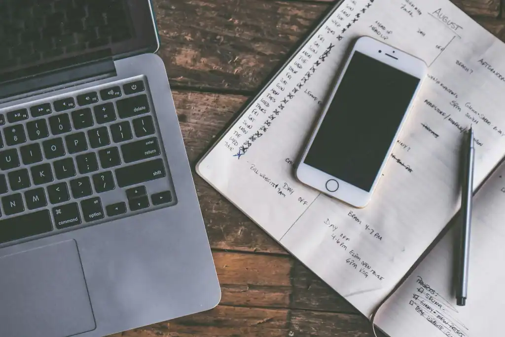 SEO Reality Check: Laptop, Smartphone und ausgedruckte Checkliste auf Holzoberfläche, von oben fotografiert – Symbolbild für strukturierte SEO-Analyse