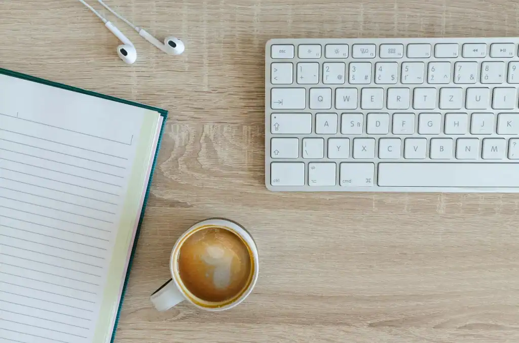 Schreibtisch_Kaffee_SEO Beratung SEO Reality Check: Laptop, Smartphone und ausgedruckte Checkliste auf Holzoberfläche, von oben fotografiert – Symbolbild für strukturierte SEO-Analyse